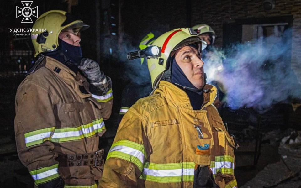 Firemen look up at the Park Hotel, which was hit by a Russian S-300 missile strike on Wednesday