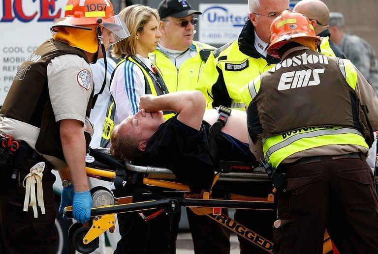 A man is loaded into an ambulance after he was injured by one of two explosions at the Boston Marathon on April 15, 2013