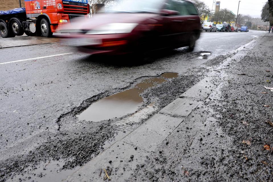 A car driving around a pothole on the road. PIC: Ben Birchall/PA Wire