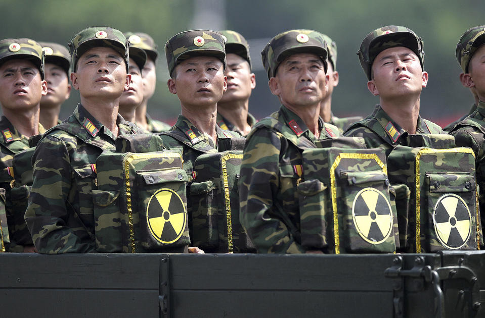 Soldados norcoreanos sosteniendo mochilas con símbolos nucleares