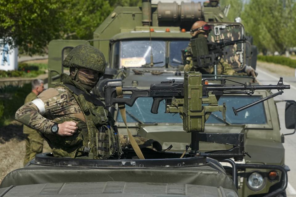 FILE - Armed Russian servicemen stand atop their military vehicles near the Zaporizhzhia Nuclear Power Station, the largest nuclear power plant in Europe and among the 10 largest in the world, in Enerhodar, Zaporizhzhia region, in territory under Russian military control, southeastern Ukraine, May 1, 2022. Some in the West think Russian President Vladimir Putin may use the Victory Day on May 9 when Russia celebrates the defeat of Nazi Germany in World War II to officially declare that war is underway in Ukraine and announce a mobilization _ the claim rejected by the Kremlin. (AP Photo/Alexander Zemlianichenko, File)