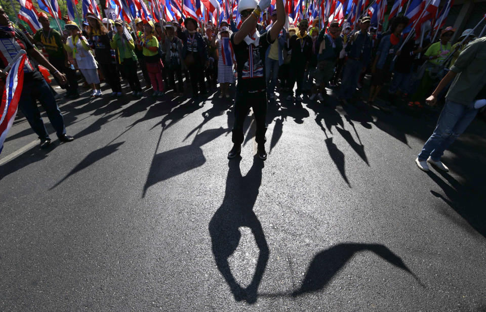 Anti-government protesters wave national flags while marching during a rally Wednesday, Jan. 15, 2014, in Bangkok, Thailand. Thailand's Prime Minister Yingluck Shinawatra said Wednesday that elections due in less than three weeks will go ahead despite intense pressure by her opponents to postpone the vote. The vow came after an overnight shooting attack on anti-government protesters in Bangkok wounded two people and ratcheted up tensions in the country's deepening political crisis. (AP Photo/Wason Wanichakorn)