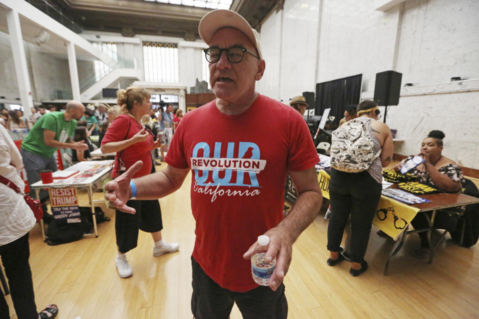 Jon Pelzer of Los Angeles attends a speech by New York congressional candidate Alexandria Ocasio-Cortez at a fundraiser in Los Angeles Thursday, Aug. 2, 2018. Ocasio-Cortez urged a cheering crowd to work together for universal health care and free college, and not to be deterred by those who say they can't be achieved. The rising liberal star startled the party when she defeated 10-term U.S. Rep. Joe Crowley in a New York City Democratic primary. (APPhoto/Reed Saxon)