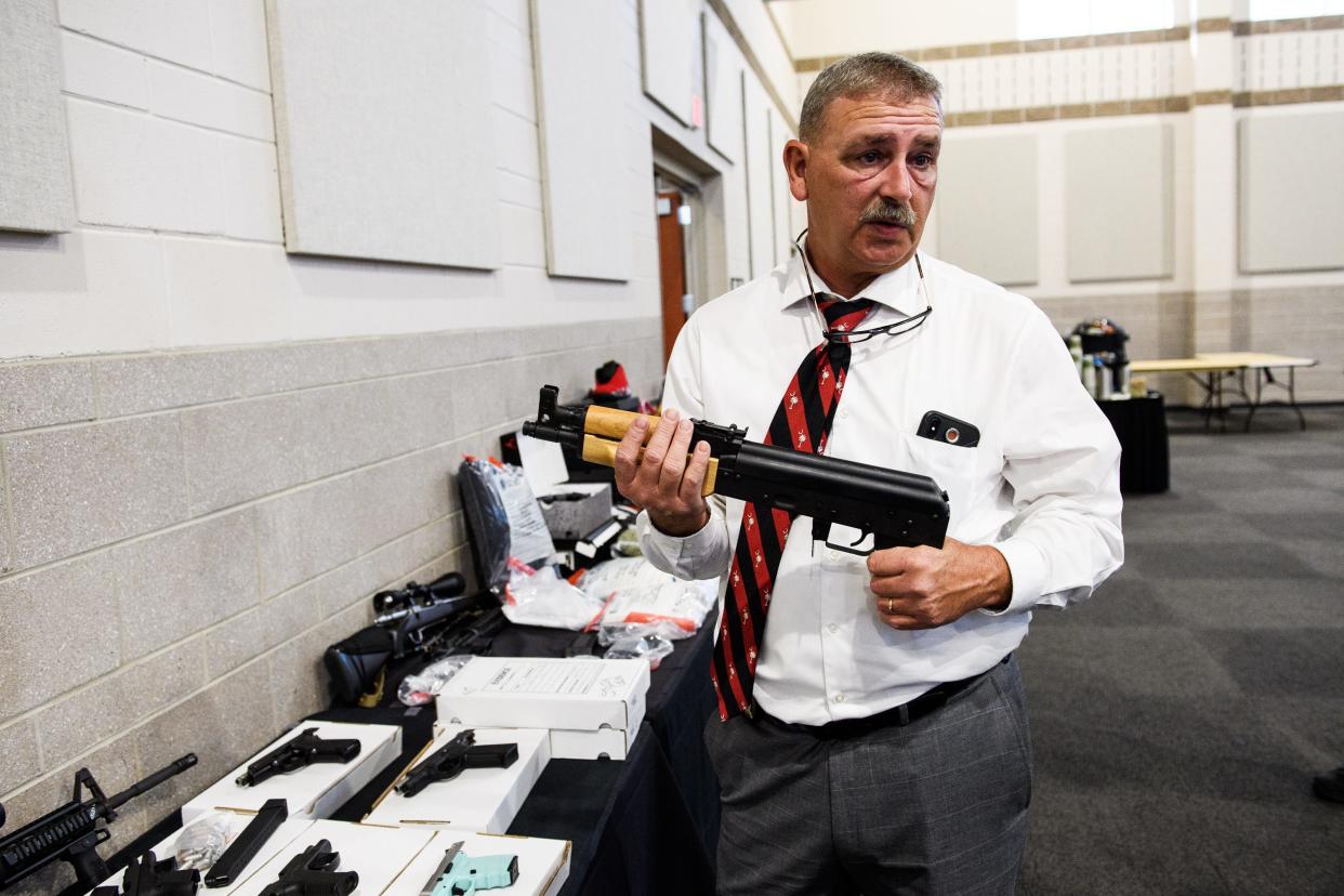 A staunch defendant of civil forfeiture, Spartanburg County Sheriff Chuck Wright holds one of the guns seized during last year's Operation Rolling Thunder on Friday, May 4, 2018.