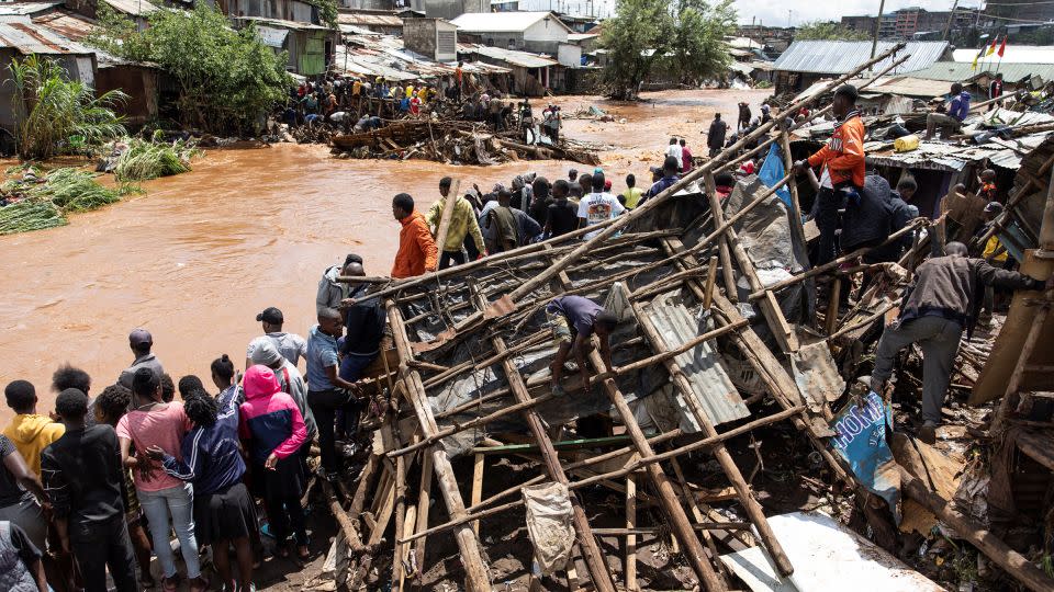 Residents of Mathare stand next to their destroyed houses by the Mathare river, following heavy rains in the capital, Nairobi, on April 24. - Simon Maina/AFP/Getty Images