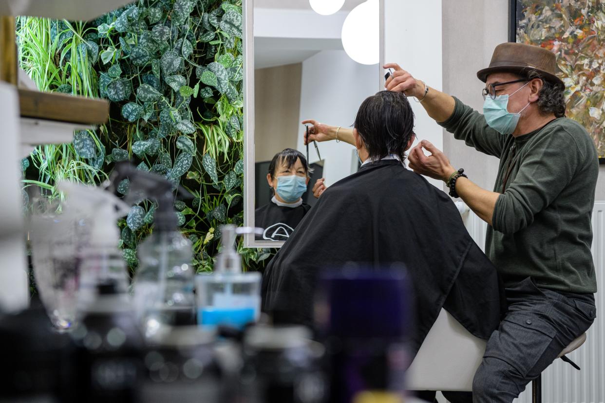 Hairdresser Andreas Garzareck-Walther cuts the hair of a customer on the first day it reopened following a hard lockdown during the novel coronavirus pandemic on March 1, 2021, in Halle, Germany.