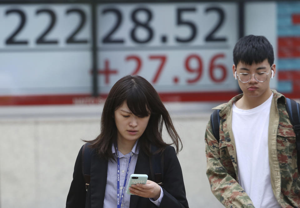 People walk by an electronic stock board of a securities firm in Tokyo, Monday, April 22, 2019. Asian stock markets were mixed Monday following the Easter holiday weekend as investors looked ahead to U.S. and Japanese economic data. (AP Photo/Koji Sasahara)