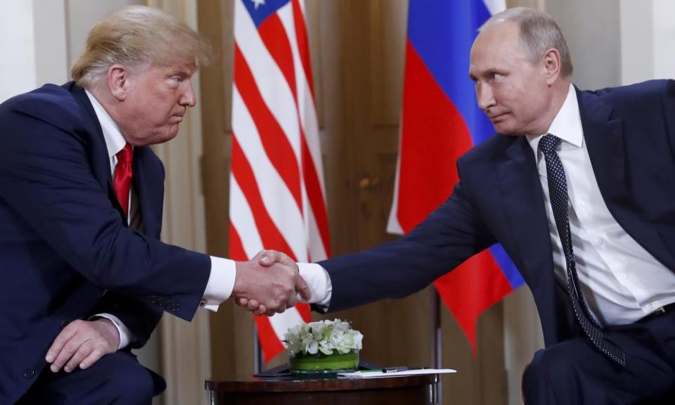 Donald Trump, left, and Vladimir Putin shake hands.