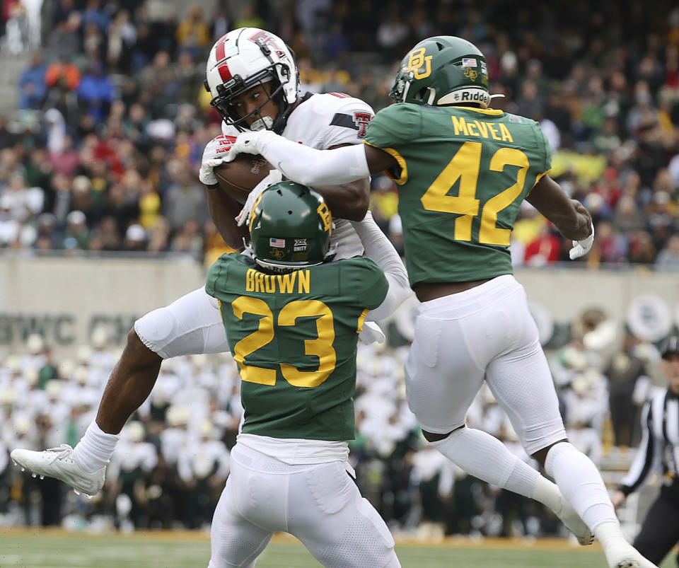 Texas Tech wide receiver Kaylon Geiger catches a pass between Baylor cornerback Zeke Brown and safety Jairon McVea, right, in the first half of an NCAA college football game Saturday, Nov. 27, 2021, in Waco, Texas. (AP Photo/Jerry Larson)