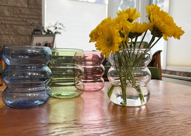 4 colors of target's glass bubble vase, one with flowers, on table