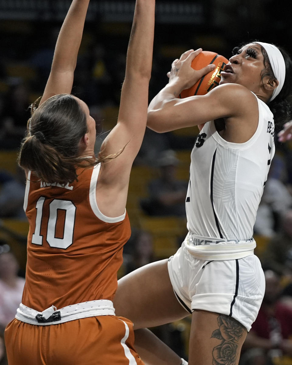 Central Florida guard Kaitlin Peterson, right, goes up for a shot over Texas guard Shay Holle (10) during the first half of an NCAA college basketball game, Saturday, Feb. 24, 2024, in Orlando, Fla. (AP Photo/John Raoux)