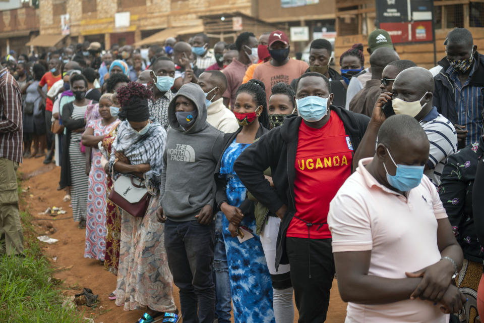 FILE - In this Thursday, Jan. 14, 2021 file photo, Ugandans wait to vote in the presidential election in Kampala, Uganda. The United States said Friday, April 16, 2021 that it is imposing visa restrictions on "those believed to be responsible for, or complicit in, undermining the democratic process in Uganda," including during the election in January and the campaign period. (AP Photo/Jerome Delay, File)