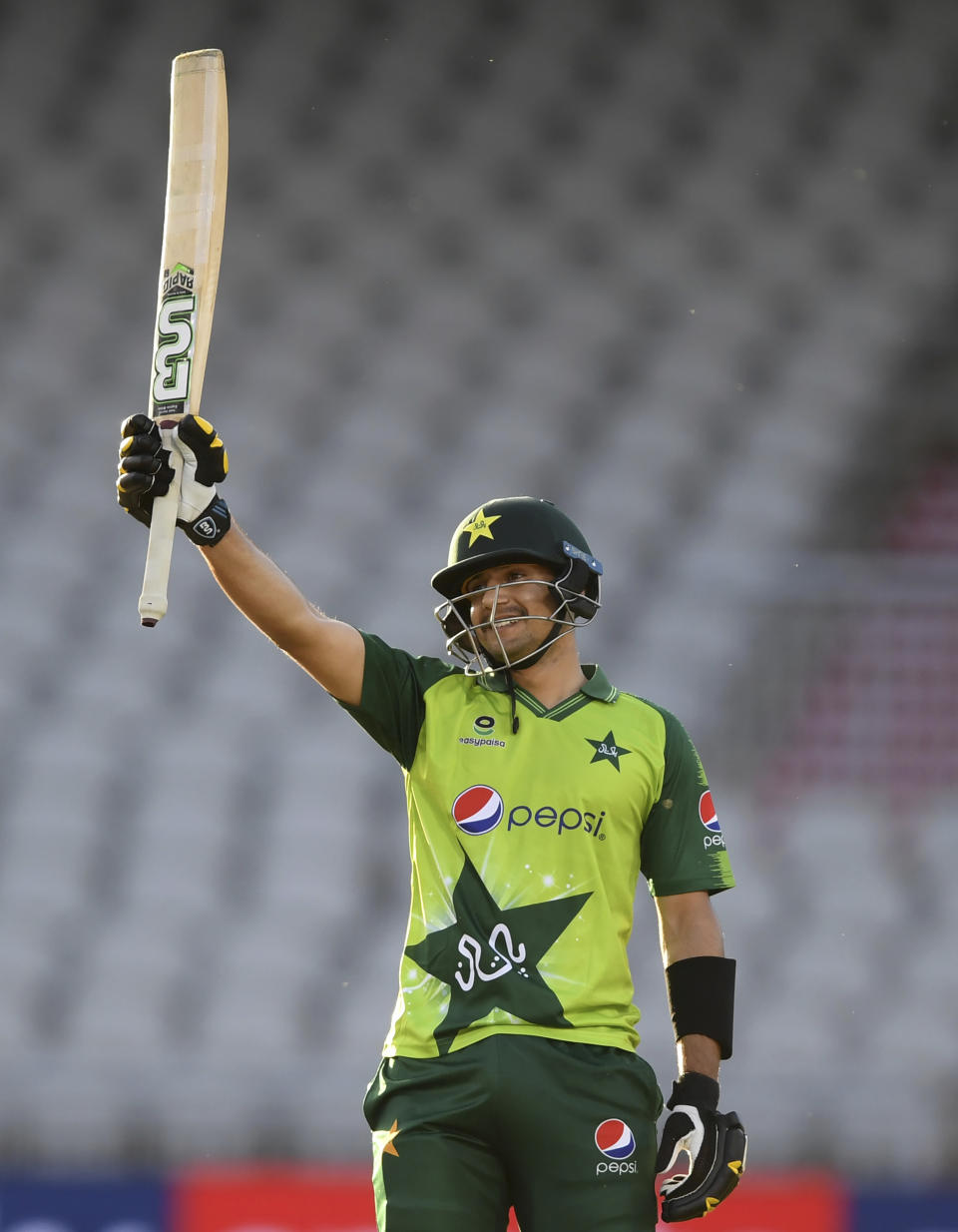 Pakistan's Haider Ali raises his bat to celebrate scoring fifty runs during the third Twenty20 cricket match between England and Pakistan, at Old Trafford in Manchester, England, Tuesday, Sept. 1, 2020. (Mike Hewitt/Pool via AP)