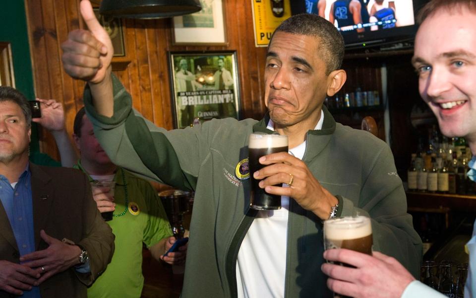 Obama gives a thumbs-up as he celebrates St. Patrick's Day with a pint of Guinness during a stop at the Dubliner Irish pub in Washington - Credit: Reuters 