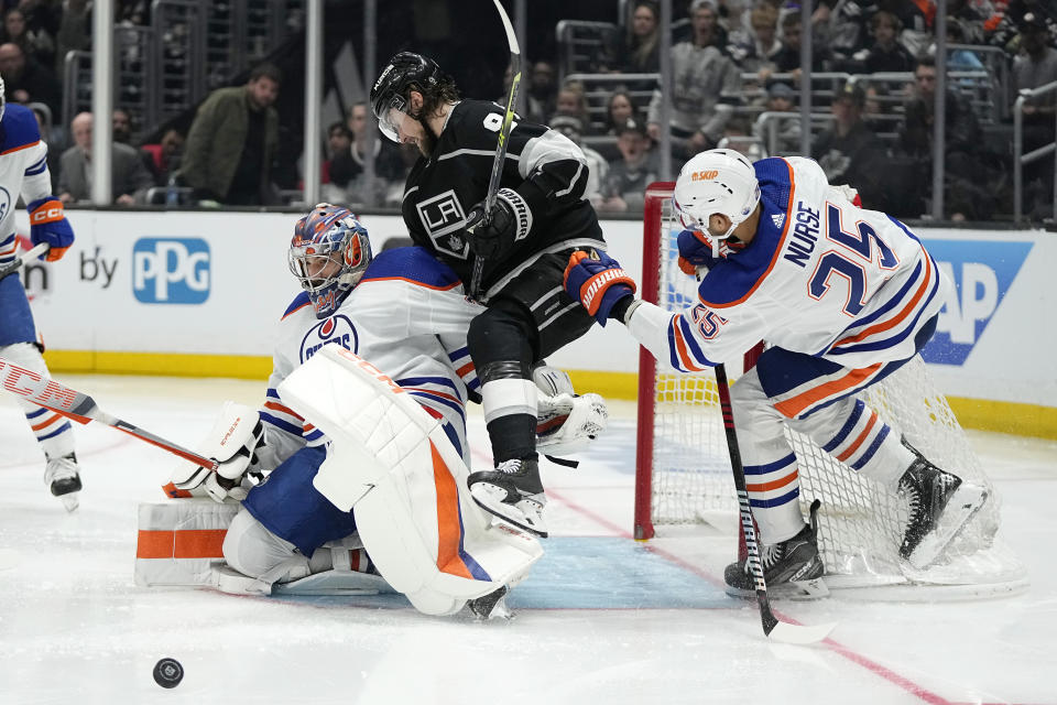 Los Angeles Kings right wing Adrian Kempe, center, collides with Edmonton Oilers goaltender Stuart Skinner, left, as defenseman Darnell Nurse helps defend during overtime in Game 3 of an NHL hockey Stanley Cup first-round playoff series Friday, April 21, 2023, in Los Angeles. (AP Photo/Mark J. Terrill)