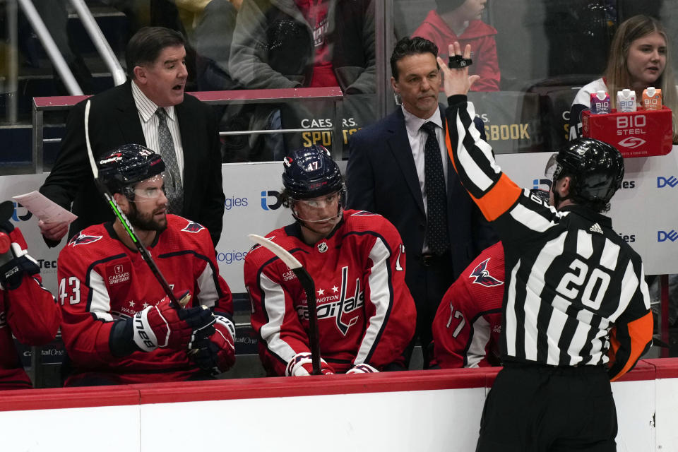 Washington Capitals head coach Peter Laviolette, top left, calls to referee Mitch Dunning (20) during the first period of an NHL hockey game against the St. Louis Blues, Friday, March 17, 2023, in Washington. (AP Photo/Carolyn Kaster)