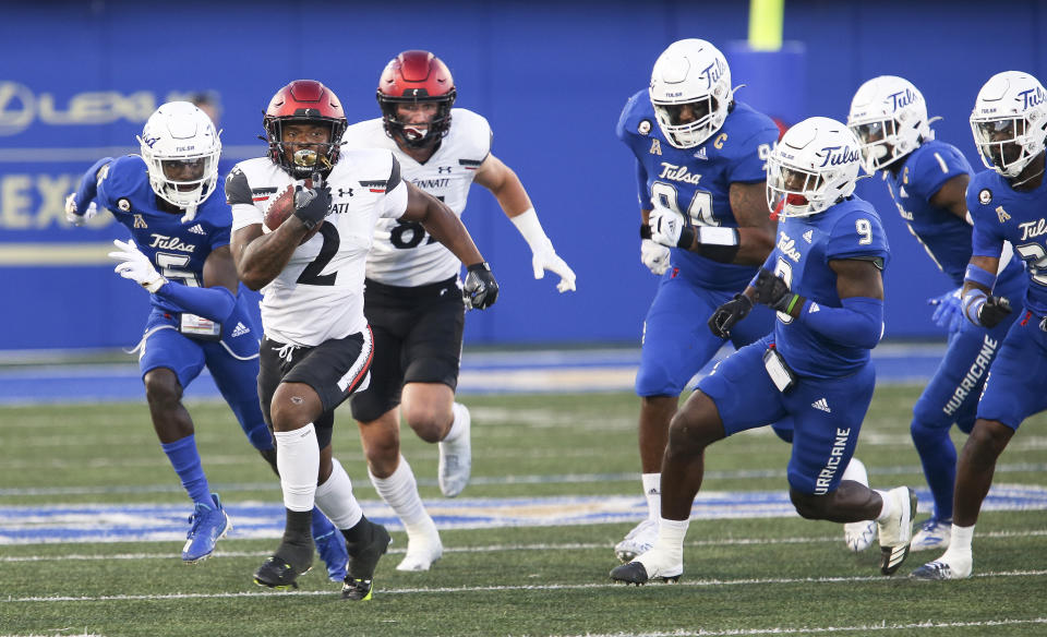 Cincinnati's Corey Kiner runs away from Tulsa defenders during the first half of an NCAA college football game in Tulsa, Okla., Saturday, Oct. 1, 2022. (AP Photo/Dave Crenshaw)