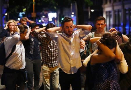 People leave the area with their hands up after an incident near London Bridge in London, Britain June 4, 2017. REUTERS/Neil Hall