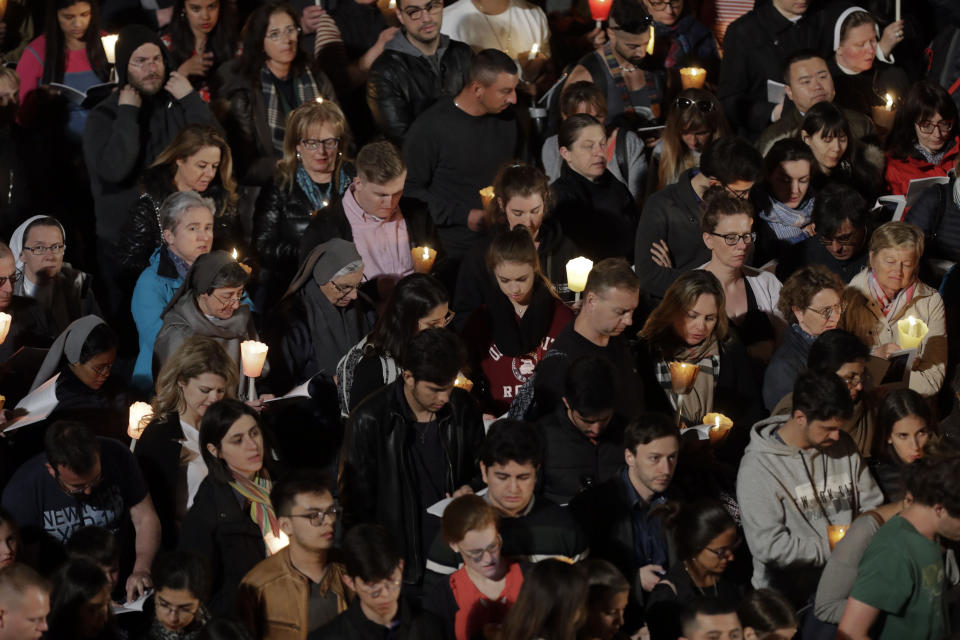 People attend as Pope Francis presides over the Via Crucis (Way of the Cross) torchlight procession on Good Friday, a Christian holiday commemorating the crucifixion of Jesus Christ and his death at Calvary, in front of Rome's Colosseum, in Rome, Friday, April 19, 2019. (AP Photo/Andrew Medichini)