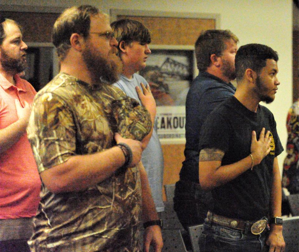 Guests say the pledge of allegiance before Oath Keepers founder Stewart Rhodes speaks Thursday, June 24, 2021, at Red River Harley-Davidson.