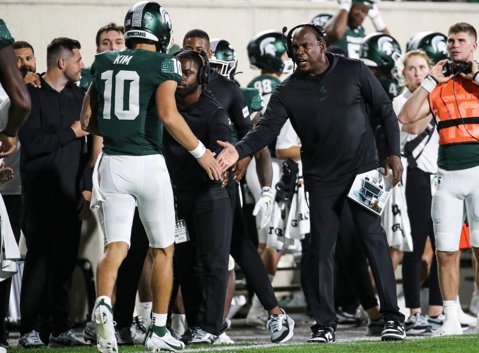 Michigan State head coach Mel Tucker shakes hands with quarterback Noah Kim (10) after a touchdown against Central Michigan during the second half at Spartan Stadium in East Lansing on Friday, Sept. 1, 2023.