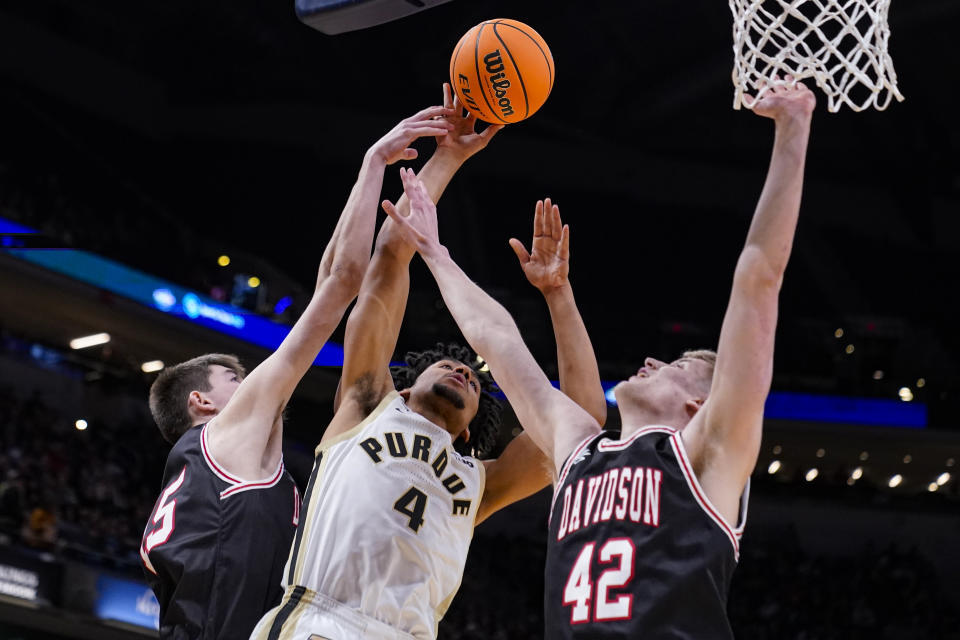 Purdue forward Trey Kaufman-Renn (4) shoots between Davidson forward Sean Logan (15) and forward David Skogman (42) in the first half of an NCAA college basketball game in Indianapolis, Saturday, Dec. 17, 2022. (AP Photo/Michael Conroy)