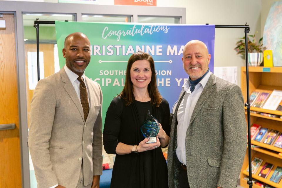 Christianne May, center, displays her award for being named Southeast Region Principal of the Year. May is the principal at Castle Hayne Elementary School.