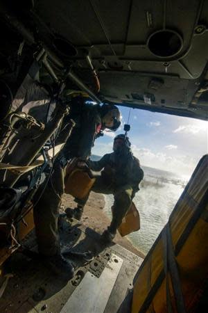 A U.S. Navy MH-60S helicopter drops supplies at Tacloban Air Base, Philippines, as part of relief efforts following Typhoon Haiyan November 14, 2013. REUTERS/Specialist 3rd Class Ricardo R. Guzman/US Navy/Handout