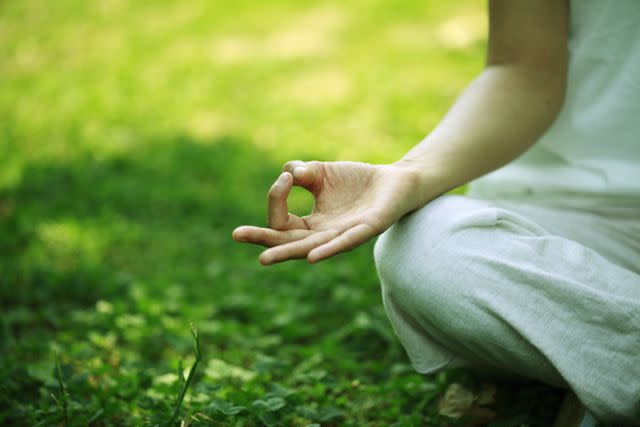 RunPhoto/Getty Images Young woman doing yoga,hand close-up