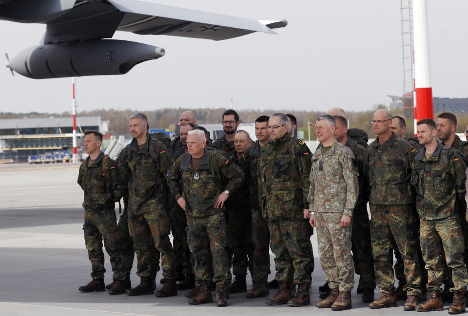 Lithuanian Chief of Defence Gen. Valdemaras Rupsys, right, and German Army Chief Lt. Gen. Alfons Mais pose with German Bundeswehr soldiers of the Headquarters initial command element of the Bundeswehr's 45th Brigade Lithuania at airport in Vilnius, Lithuania, Monday, April 8, 2024. Germany has made a commitment to deploy a heavy brigade with three maneuver battalions and all necessary enablers, including combat support and provision units, to Lithuania. In total, approx. 5 thousand German military and civilian personnel are expected to move to Lithuania with families in stationing the Brigade. (AP Photo/Mindaugas Kulbis)