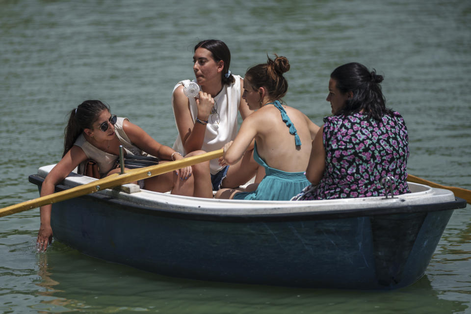 A group of women relax on a rowing boat in the Retiro park lake in Madrid, Spain, Monday, July 17, 2023. Spain’s Aemet weather agency said the heat wave this week “will affect a large part of the countries bordering the Mediterranean“ with temperatures in some southern areas of Spain exceeding 42 C (107 F). (AP Photo/Manu Fernandez)