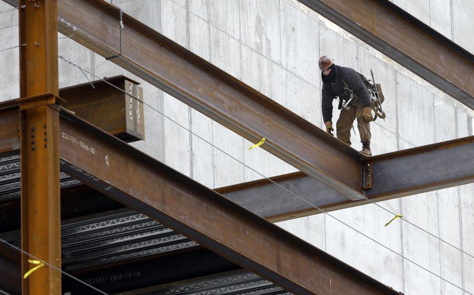 In this Tuesday, April 29, 2014 photo, a worker positions iron girders at a building construction site, in Boston. The Labor Department releases first-quarter productivity data on Wednesday, May 7, 2014. (AP Photo/Steven Senne)