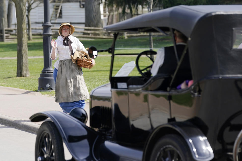 A worker waves at a passing Ford Model T at The Henry Ford, Friday, April 14, 2023, in Dearborn, Mich. Named after Ford Motor Co. founder and American industrialist Henry Ford, The Henry Ford sits on 250 acres and features a museum and Greenfield Village where more than 80 historic structures are displayed and maintained. The Jackson House from Selma, Ala., will join the courthouse where Abraham Lincoln first practiced law, the laboratory where Thomas Edison perfected the light bulb and the home and workshop where Orville and Wilbur Wright invented their first airplane. (AP Photo/Carlos Osorio)