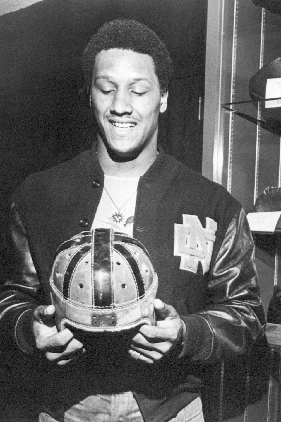 FILE - University of Notre Dame's Ross Browner smiles after being named Associated Press Lineman of the Week, at South Bend, Ind., Wednesday, Oct. 27, 1976. The Notre Dame junior defensive end had 11 tackles including five for losses against South Carolina on Saturday, Oct. 23. Browner, a two-time All-American at Notre Dame and one of four brothers who played in the NFL, has died. He was 67. Browner's son, former NFL offensive lineman Max Starks, posted on Twitter early Wednesday morning, Jan. 5, 2022, that his father had died. Browner is holding a pre-World War II Notre Dame helmet. (AP Photo/File)