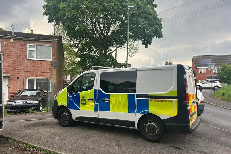 Police van outside house on Newarmket Close, Bulwell, with black car with no numberplate visible parked on grass outside house on left