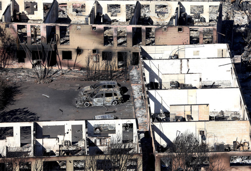 Burned cars sit in front of an apartment building that was destroyed by the wildfire in Lahaina. / Credit: Getty Images