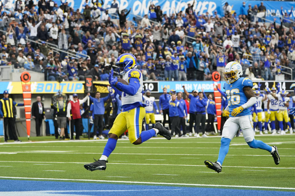 Los Angeles Rams running back Malcolm Brown (41) scores a touchdown as he is followed by Los Angeles Chargers cornerback Asante Samuel Jr. (26) during the first half of an NFL football game against the Los Angeles Chargers Sunday, Jan. 1, 2023, in Inglewood, Calif. (AP Photo/Marcio Jose Sanchez)