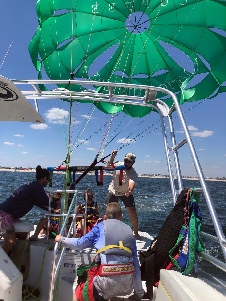 Point Pleasant Parasail owner CJ Titmas and Greg Lins prepare customers to take flight.