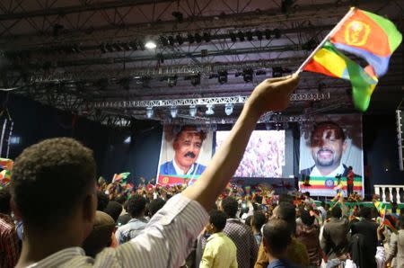 A civilian waves the Ethiopian and Eritrean national flags during a concert at the Millennium Hall in Addis Ababa, Ethiopia July 15, 2018. REUTERS/Tiksa Negeri