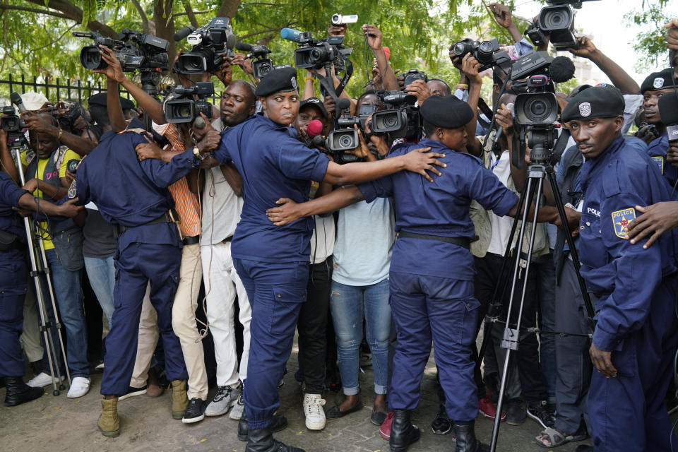 Congolese police officers hold back members of the media as Congo opposition candidate Martin Fayulu leaves the constitution court in Kinshasa, Congo, Saturday Jan. 12, 2019. The ruling coalition of Congo's outgoing President Joseph Kabila has won a large majority of national assembly seats, the electoral commission announced Saturday, while the presidential election runner-up was poised to file a court challenge alleging fraud. (AP Photo/Jerome Delay)