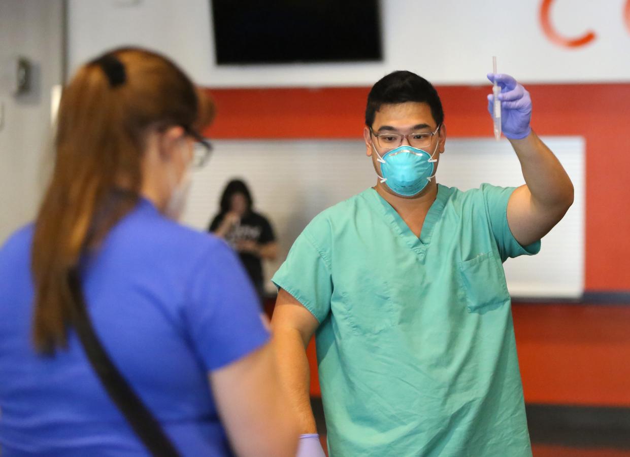 A physician's assistant at UF Health gives directions to a group of students on how to properly take a COVID-19 spit test at the O'Connell Center on campus in Gainesville on Sept. 23.