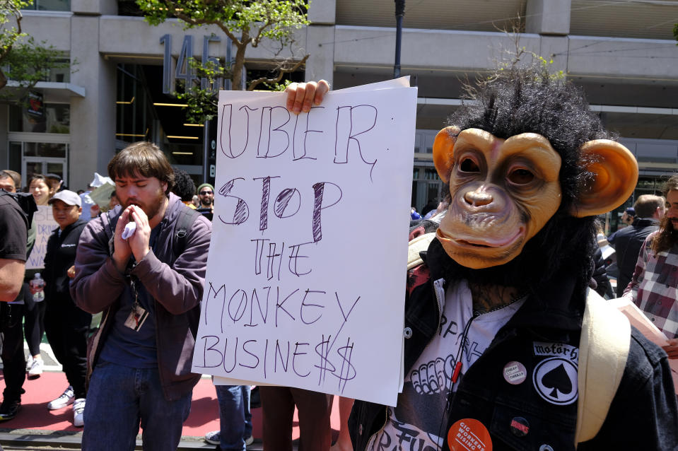 Protesters hold a rally and stop traffic on Market Street outside of Uber headquarters Wednesday, May 8, 2019, in San Francisco. Some drivers for ride-hailing giants Uber and Lyft turned off their apps to protest what they say are declining wages as both companies rake in billions of dollars from investors. Demonstrations in 10 U.S. cities took place Wednesday, including New York, Chicago, Los Angeles, San Francisco and Washington, D.C. The protests take place just before Uber becomes a publicly traded company Friday. (AP Photo/Eric Risberg)