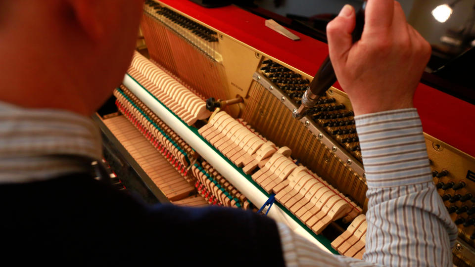 Man tuning a piano