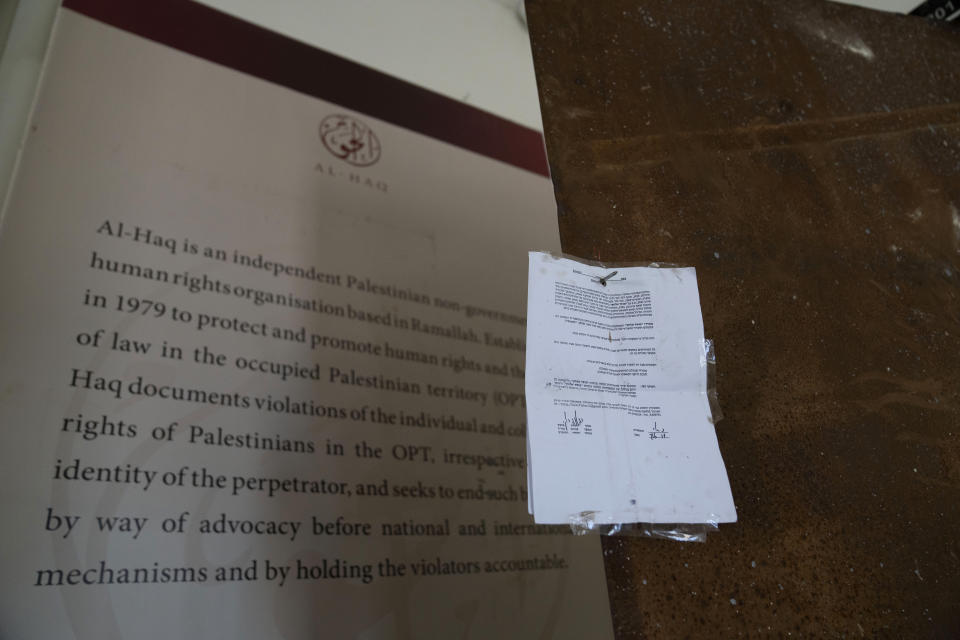 An Israeli army closure order hangs on the door of the sealed office of the al-Haq human rights organization that was raided by Israel forces, in the West Bank city of Ramallah, Thursday, Aug. 18, 2022. Israel raided the offices of several Palestinian advocacy groups it had previously designated as terrorist organizations, sealing entrance doors and leaving notices declaring them closed, the groups said Thursday. (AP Photo/Nasser Nasser)