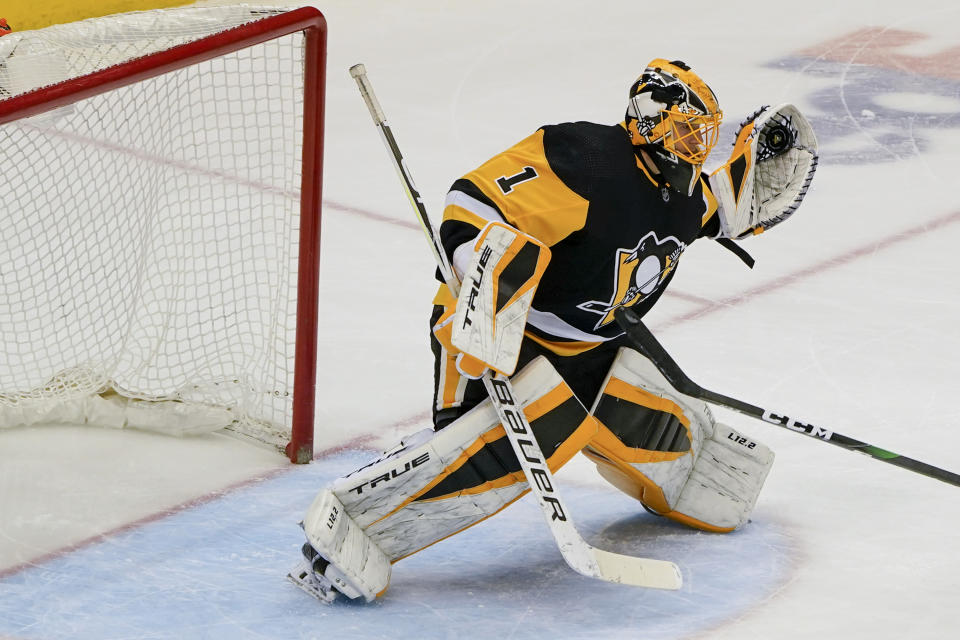 Pittsburgh Penguins goaltender Casey DeSmith (1) makes a glove-save on a shot by the New York Islanders during the third period of an NHL hockey game, Monday, March 29, 2021, in Pittsburgh. (AP Photo/Keith Srakocic)