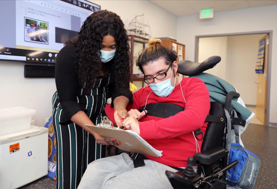 Rihanna DeLaunay, a direct care worker at Jawonio and client Alirio Magana, fill out some paperwork in a classroom  at their headquarters in New City, Nov. 2, 2021.