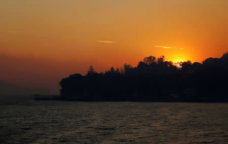 The sun sets along the shore of Clear Lake amidst the smoke of the River Fire (Mendocino Complex) in Lakeport, California, U.S. August 1, 2018. REUTERS/Fred Greaves