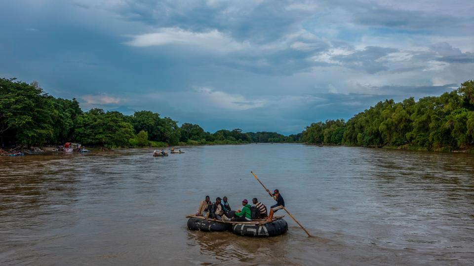 Migrants from Haiti cross the Suchiate River into Mexico from Guatemala on a raft as they make their way north to the U.S.-Mexico Border in October 2023.