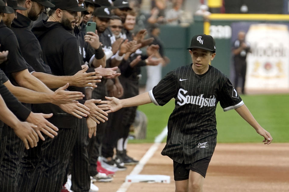 Cancer patient Brady Nelson participates in the Chicago White Sox's Ultimate Wish program as he runs the bases and is greeted by members of the baseball club before a baseball game between the White Sox and the Texas Rangers Monday, June 19, 2023, in Chicago. (AP Photo/Charles Rex Arbogast)