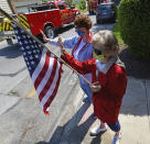 Sharon Allison, left, and Marie Piastrelli don protective masks while watching a Memorial Day parade go by their apartment building in Ebensburg, Pa., Monday, May 25. 2020. (John Rucosky/The Tribune-Democrat via AP)